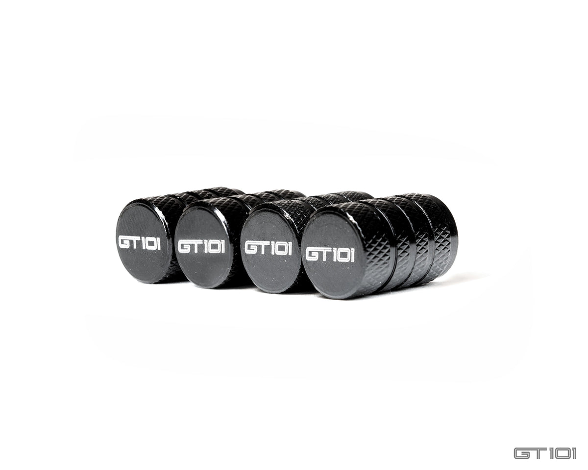Set of four GT101 black anodised billet aluminium tyre valve dust caps with diamond-knurled bodies and laser-etched GT101 logos