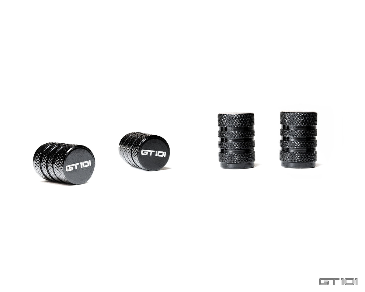 Set of four GT101 black anodised billet aluminium tyre valve dust caps with diamond-knurled bodies and laser-etched GT101 logos